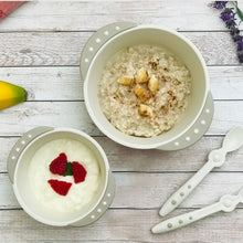 Load image into Gallery viewer, A large bowl contains oatmeal and diced banana top with cinnamon powder.  A small bowl contains plain yogurt and raspberries.
